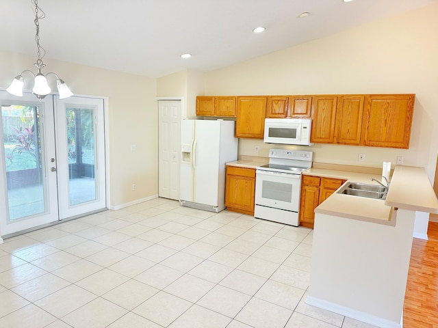 kitchen featuring sink, white appliances, a notable chandelier, decorative light fixtures, and kitchen peninsula