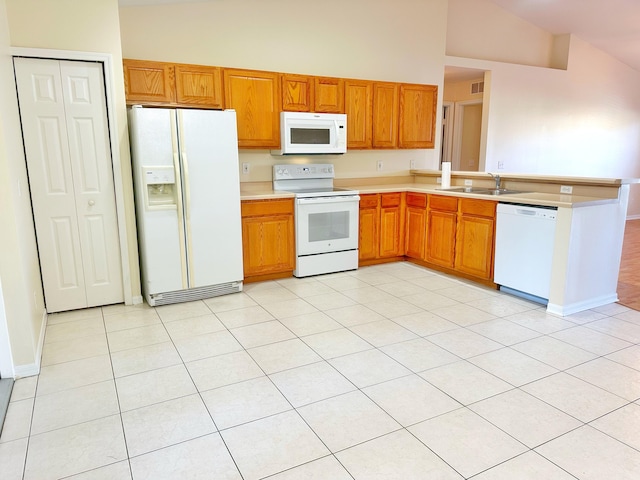 kitchen with vaulted ceiling, sink, light tile patterned flooring, and white appliances