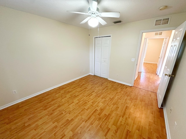 unfurnished bedroom featuring ceiling fan, light hardwood / wood-style floors, and a closet