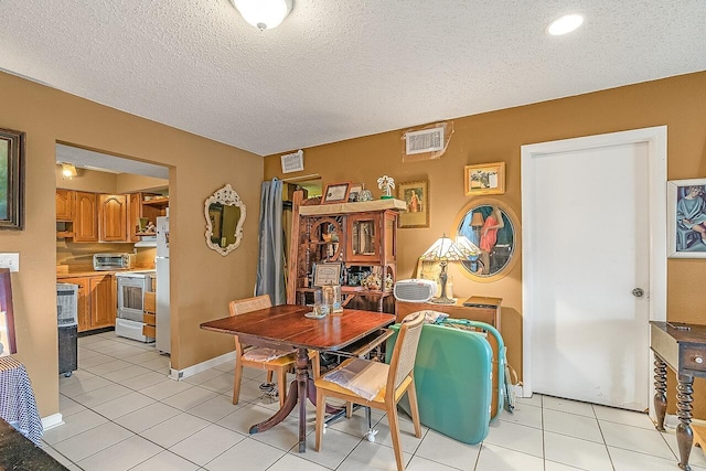 dining area featuring a textured ceiling and light tile patterned flooring