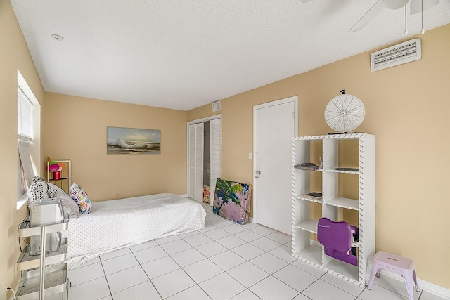 tiled bedroom with a closet and a textured ceiling