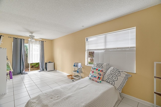 bedroom with a textured ceiling, ceiling fan, and light tile patterned flooring