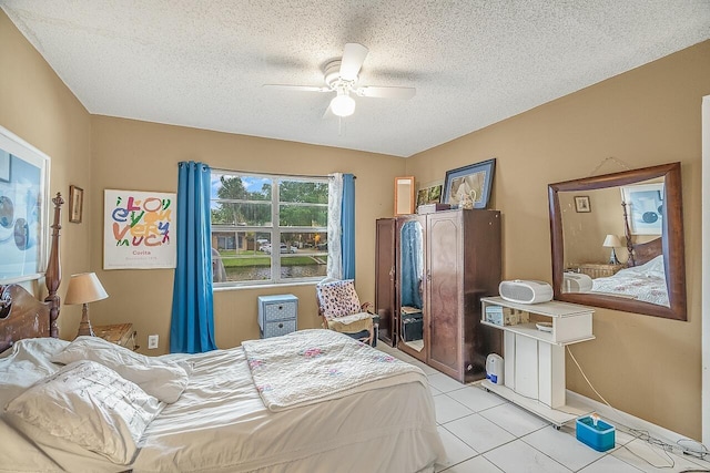 bedroom with ceiling fan, a textured ceiling, and light tile patterned flooring