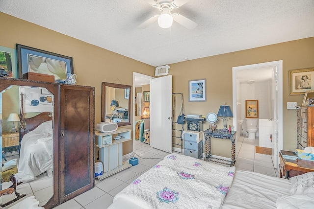 bedroom with ceiling fan, connected bathroom, light tile patterned floors, and a textured ceiling