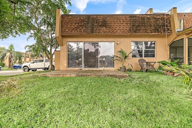 rear view of house featuring a lawn