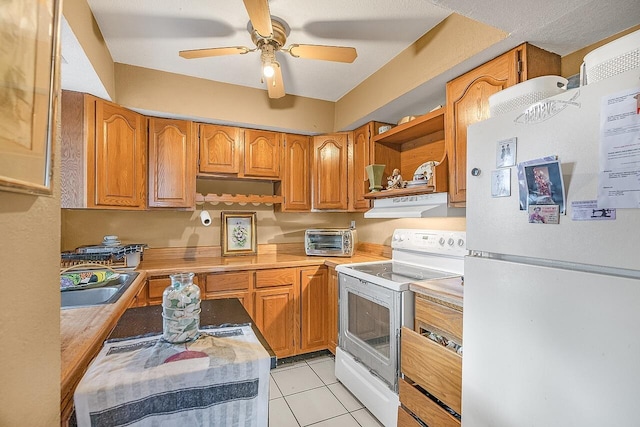 kitchen featuring light tile patterned floors, white appliances, ceiling fan, and sink