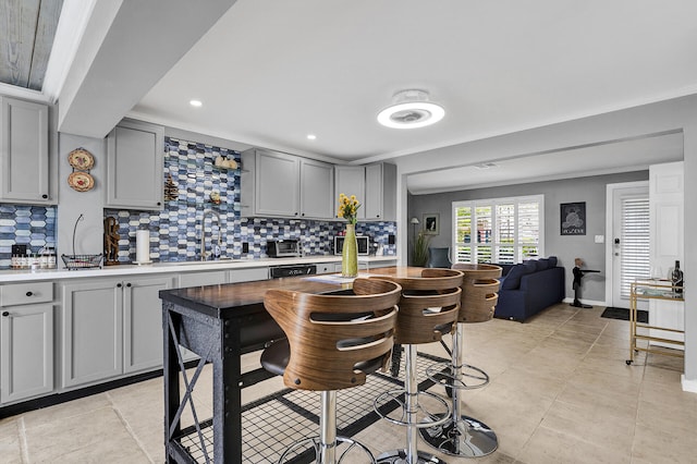 kitchen featuring gray cabinetry, decorative backsplash, sink, and ornamental molding