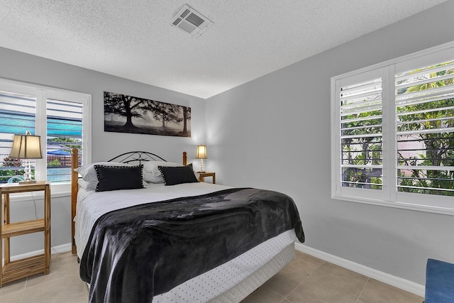 bedroom featuring light tile patterned floors and a textured ceiling