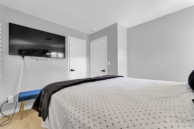 bedroom featuring light tile patterned floors and a textured ceiling