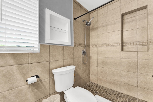 bathroom with toilet and a tile shower