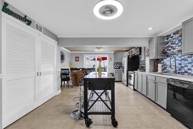 kitchen with gray cabinets, decorative backsplash, sink, and appliances with stainless steel finishes