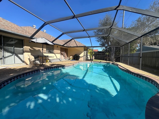 view of pool with a patio area and glass enclosure