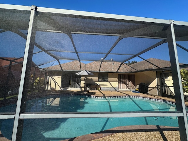 view of pool with a patio and glass enclosure