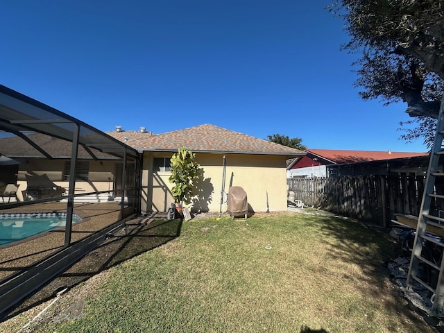 view of yard featuring a fenced in pool and glass enclosure