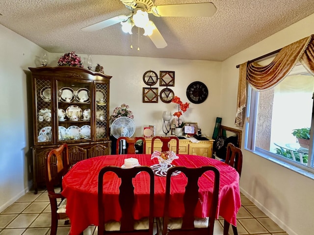 dining area with a textured ceiling, ceiling fan, and light tile patterned floors