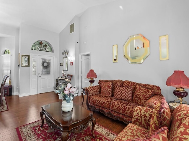 living room featuring dark hardwood / wood-style flooring and high vaulted ceiling