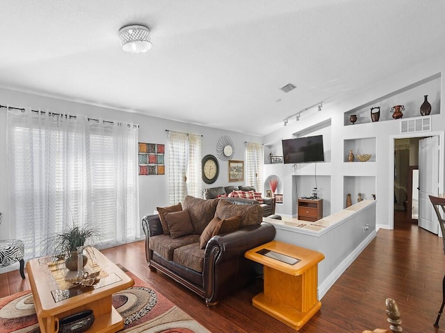 living room featuring built in shelves, track lighting, and dark wood-type flooring