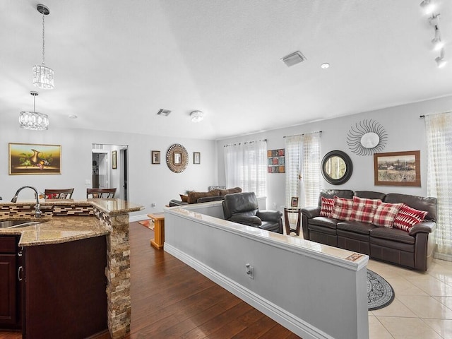 living room featuring a chandelier, light hardwood / wood-style floors, and sink