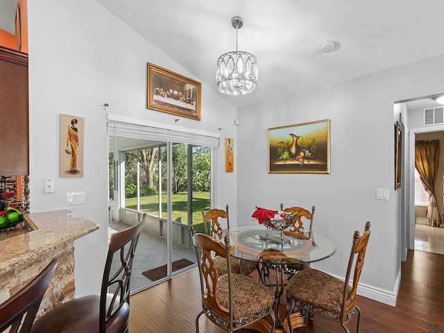 dining space featuring a notable chandelier, dark hardwood / wood-style floors, and vaulted ceiling