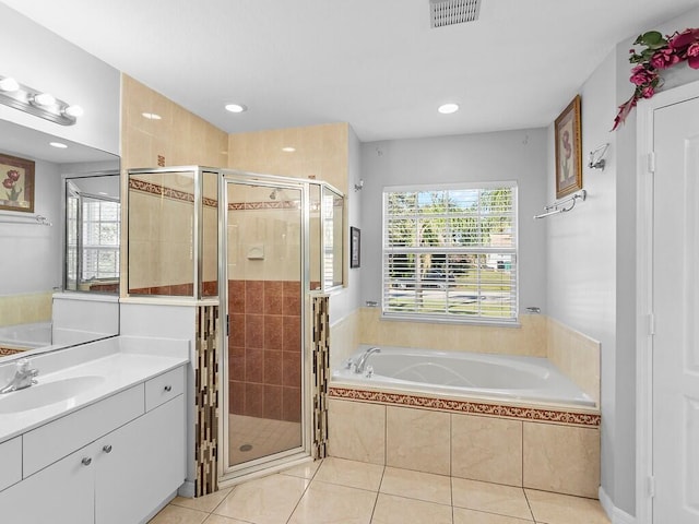 bathroom with tile patterned flooring, vanity, and plus walk in shower