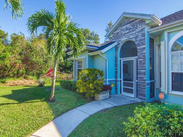 doorway to property with a lawn