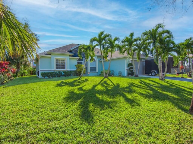 ranch-style house featuring a front lawn and a garage