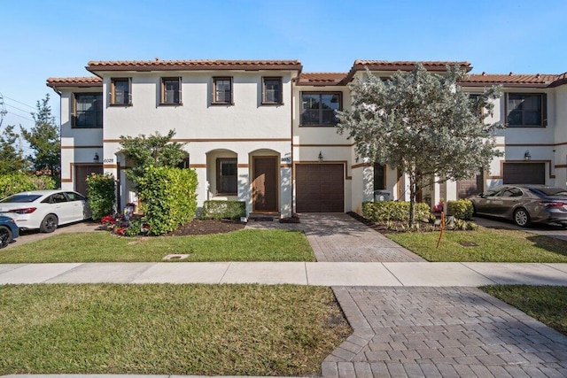 mediterranean / spanish-style house with a garage and a front lawn