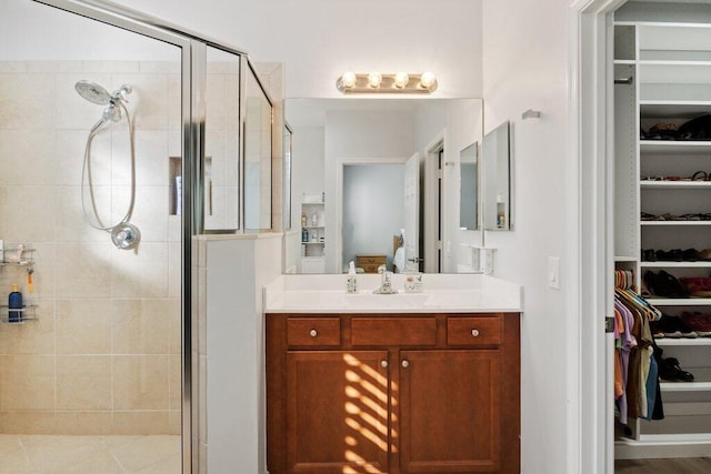 bathroom featuring a shower with door and vanity