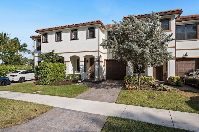 mediterranean / spanish house with a front lawn and a garage