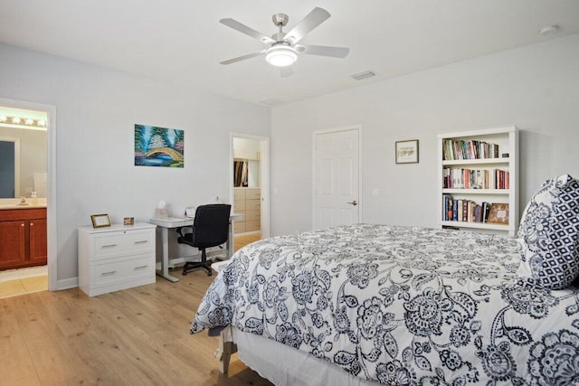 bedroom featuring ceiling fan, light wood-type flooring, sink, and ensuite bath