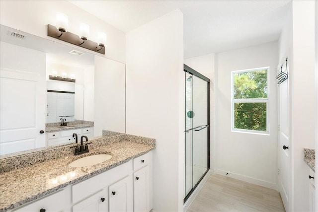 bathroom featuring vanity, wood-type flooring, and walk in shower