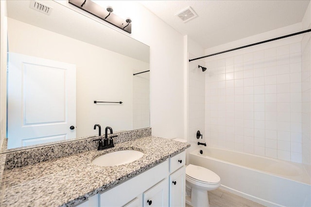 full bathroom featuring shower / washtub combination, vanity, hardwood / wood-style floors, and toilet