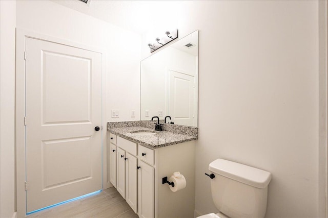 bathroom with vanity, hardwood / wood-style flooring, and toilet