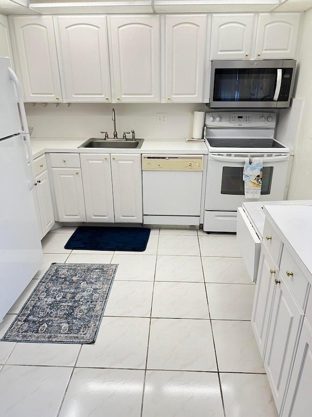 kitchen featuring white cabinets, light tile patterned floors, white appliances, and sink