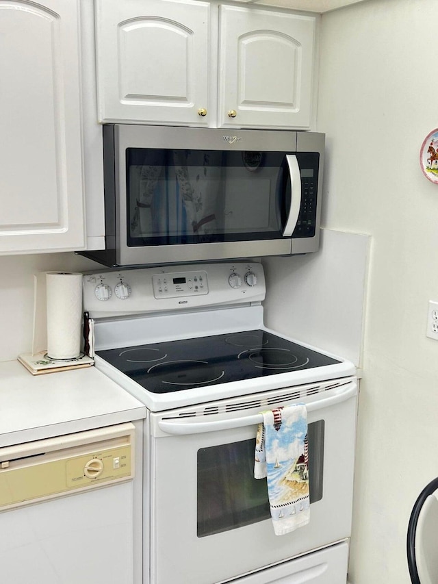 kitchen featuring white cabinetry and white appliances