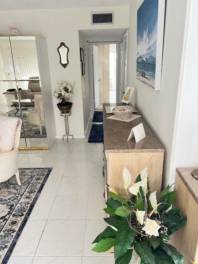 foyer featuring tile patterned floors and a textured ceiling