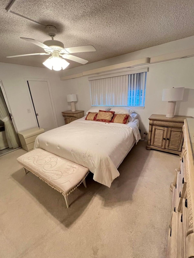 carpeted bedroom with ceiling fan and a textured ceiling