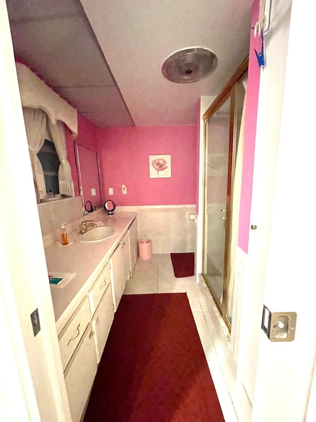 bathroom featuring tile patterned floors, vanity, and a shower with shower door