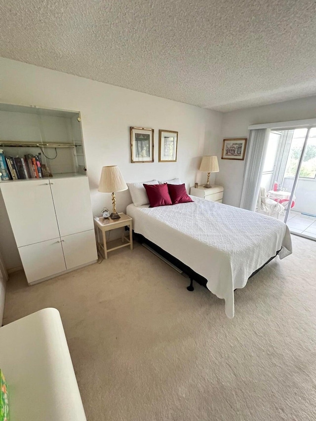 carpeted bedroom featuring access to outside and a textured ceiling