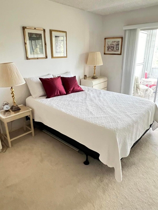 bedroom featuring a textured ceiling and light colored carpet