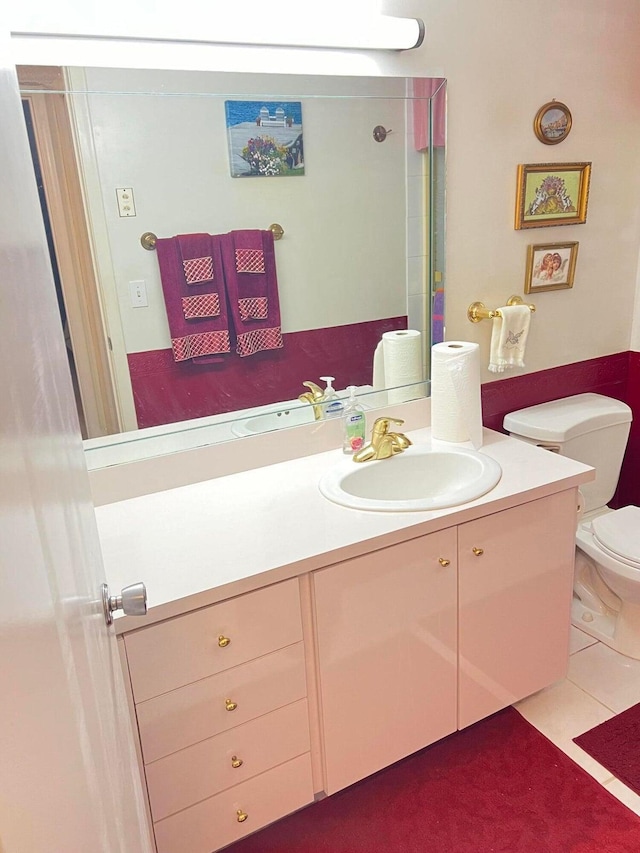 bathroom featuring tile patterned flooring, vanity, and toilet