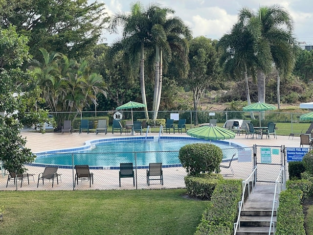 view of swimming pool featuring a lawn