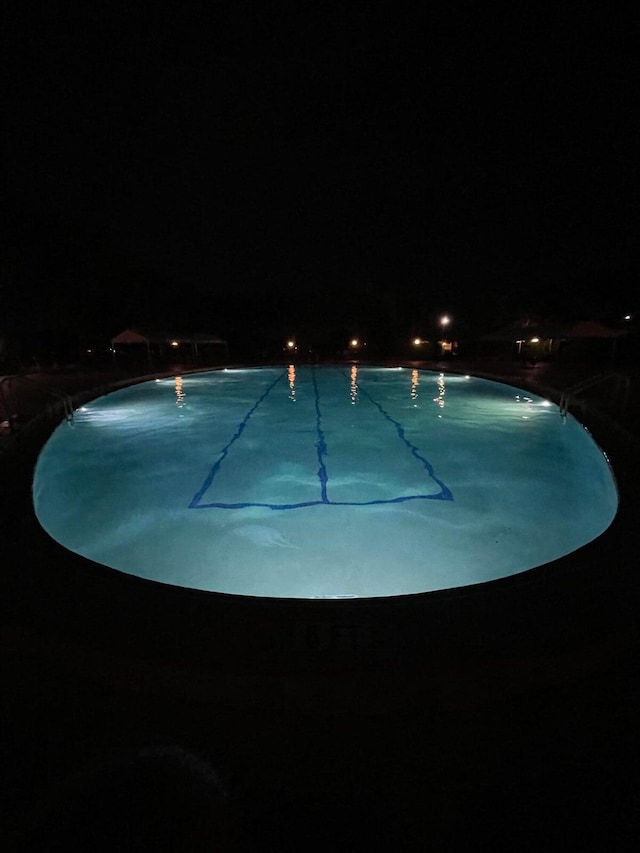 view of pool at twilight