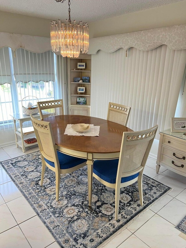 dining room with a textured ceiling, a notable chandelier, and light tile patterned flooring