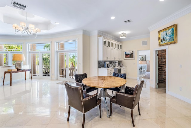 dining area with french doors, an inviting chandelier, a raised ceiling, and ornamental molding