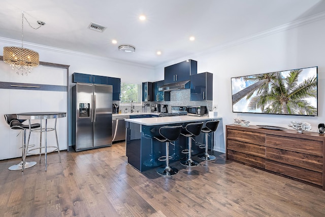 kitchen featuring a kitchen breakfast bar, blue cabinets, stainless steel appliances, and kitchen peninsula