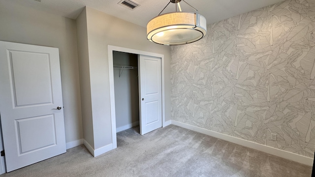 unfurnished bedroom featuring a closet and light colored carpet