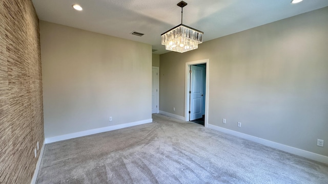 unfurnished room featuring light carpet and an inviting chandelier