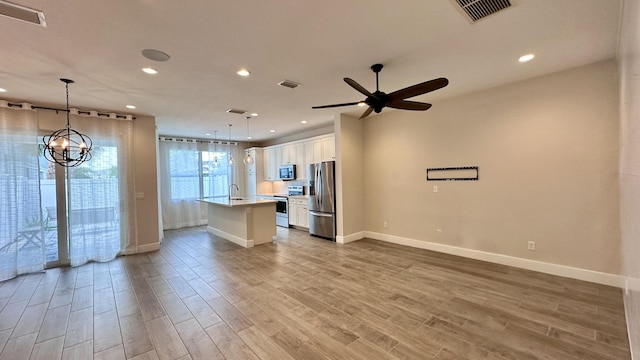 interior space featuring ceiling fan with notable chandelier