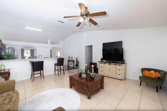 living room with ceiling fan, light tile patterned floors, and vaulted ceiling